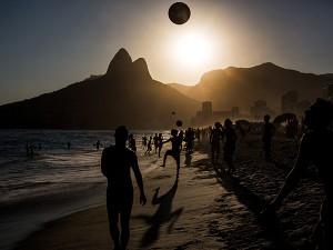 People playing soccer ball on Ipanema beach at sunset, Rio de Janeiro.
